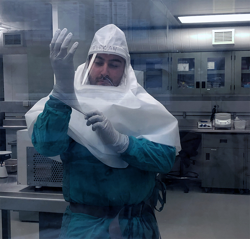 researcher wearing full body protection to work with coronavirus